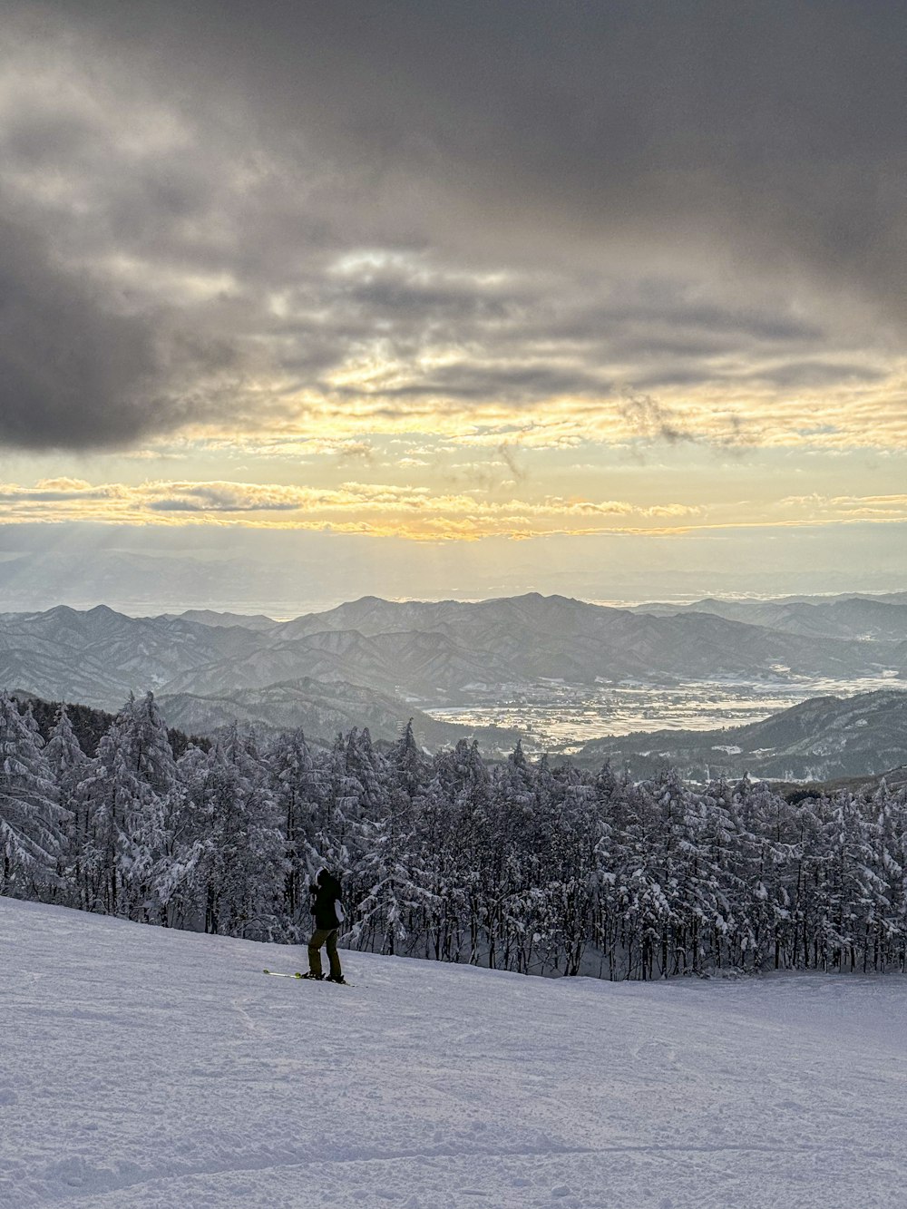 a person standing on top of a snow covered slope