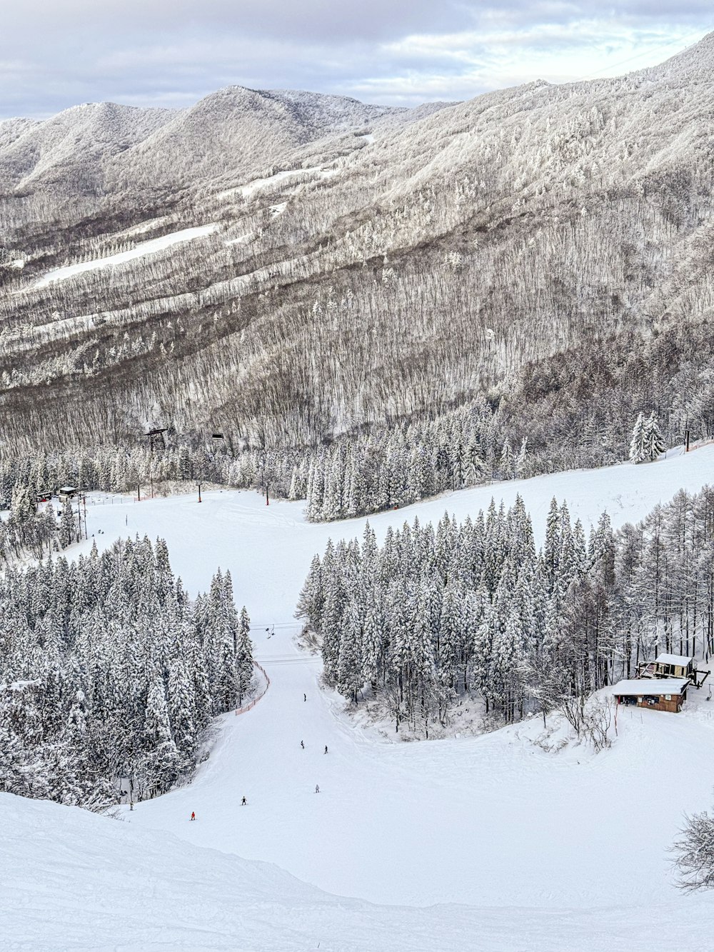 a snow covered mountain with a ski lodge in the distance