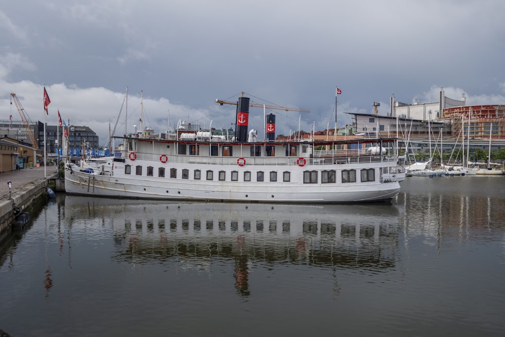 a large white boat sitting next to a dock