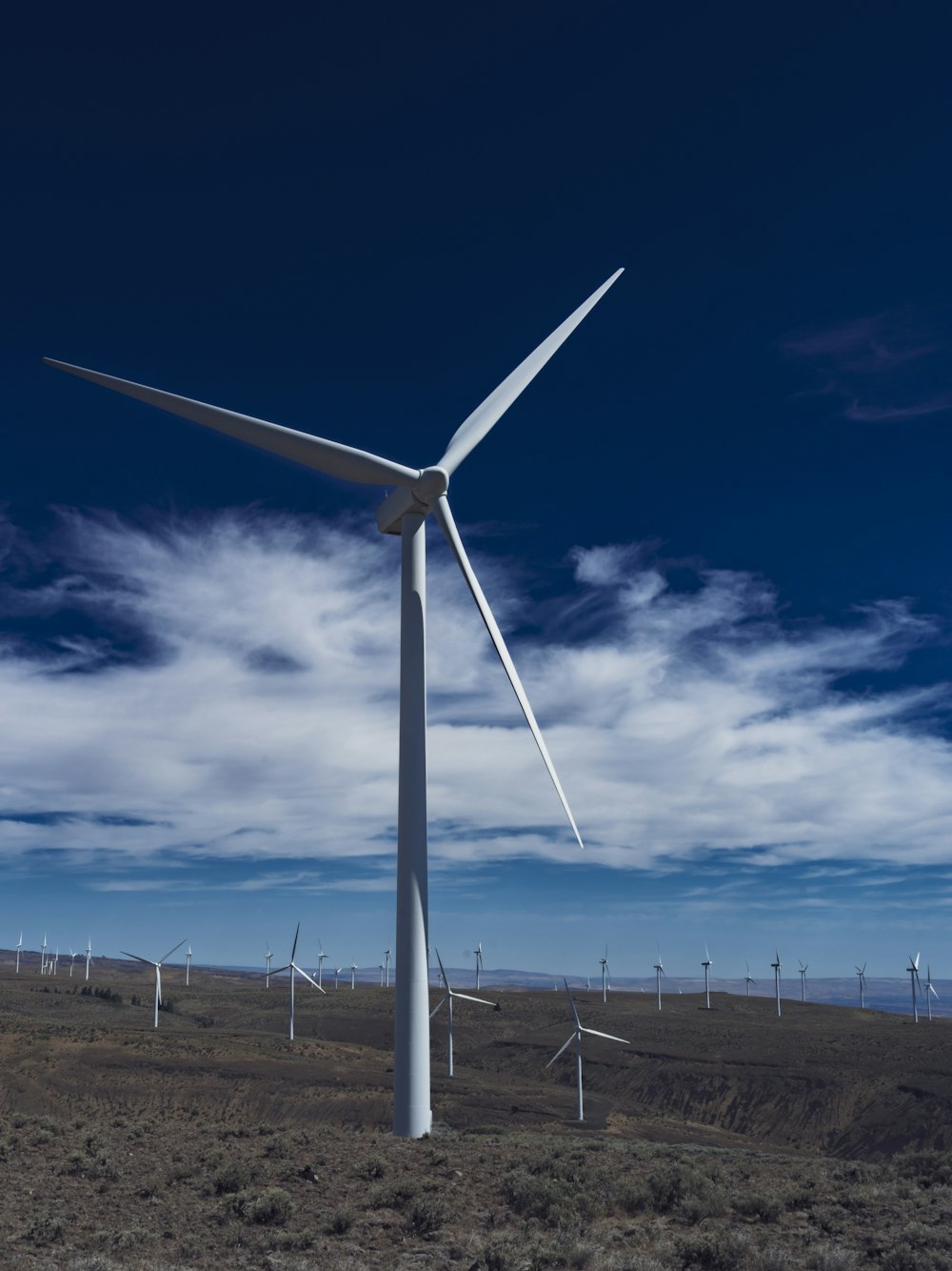 a wind farm with several windmills in the background