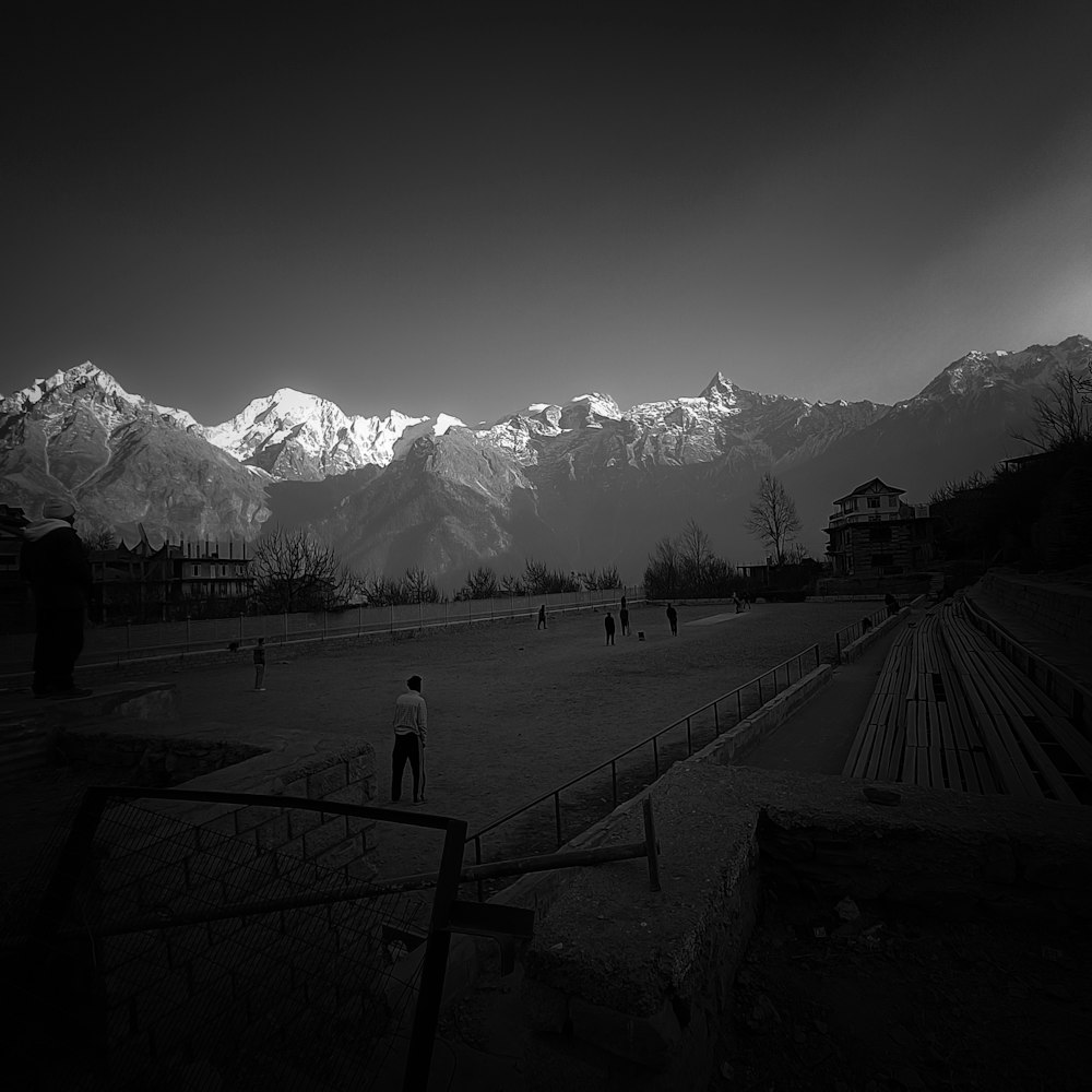 Una foto en blanco y negro de un campo con montañas de fondo
