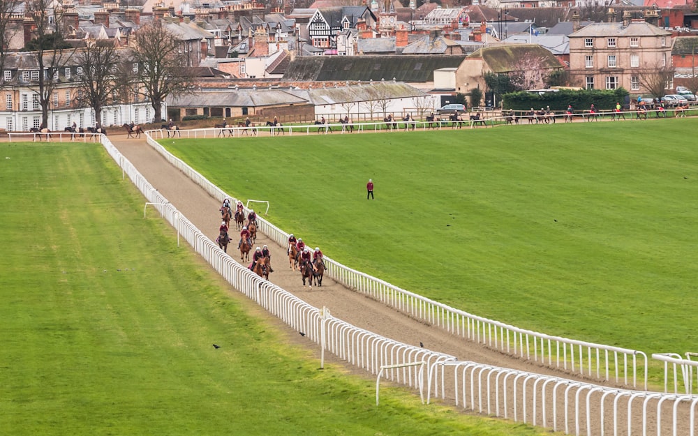 a group of people riding horses down a race track