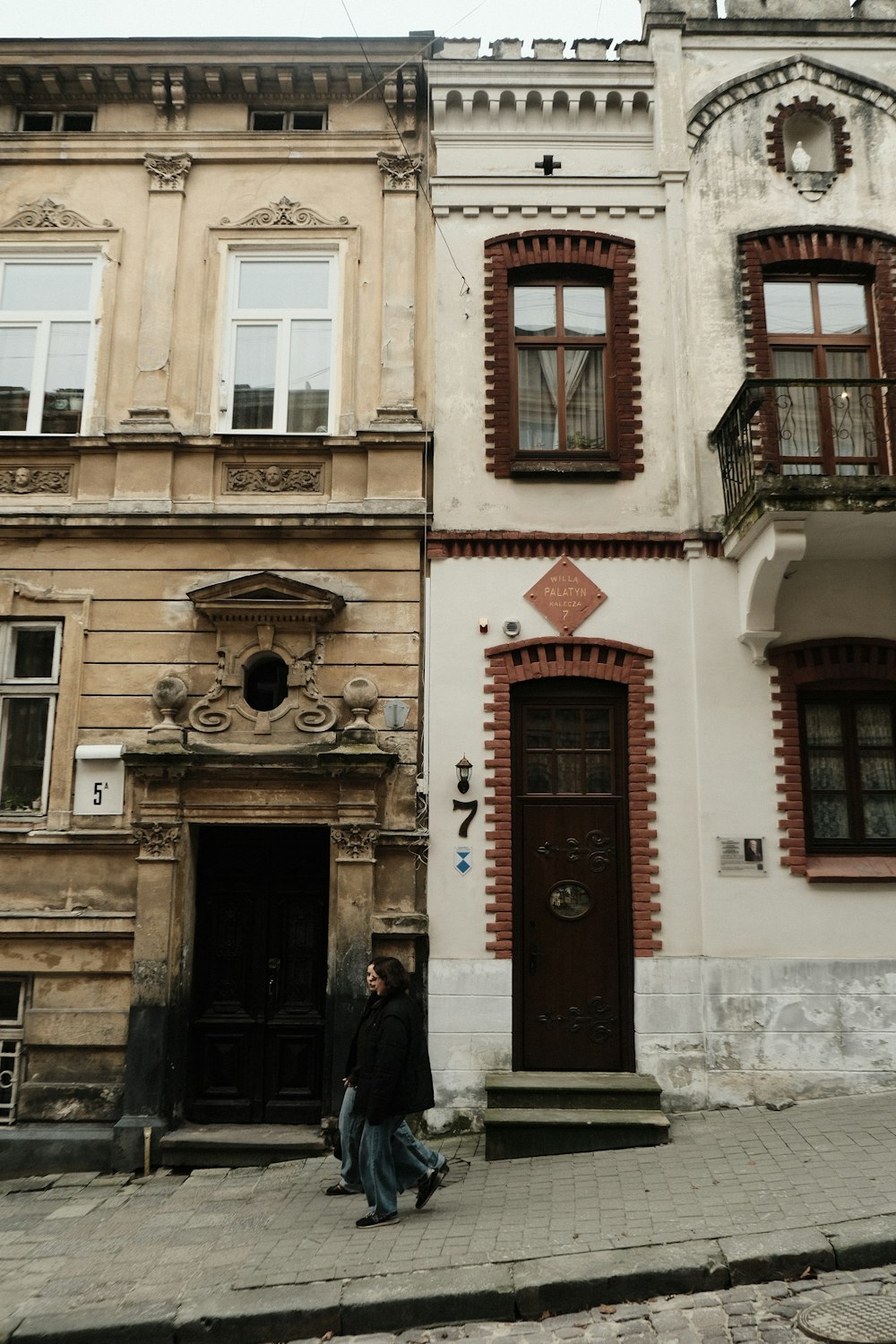 a person sitting on the sidewalk in front of a building