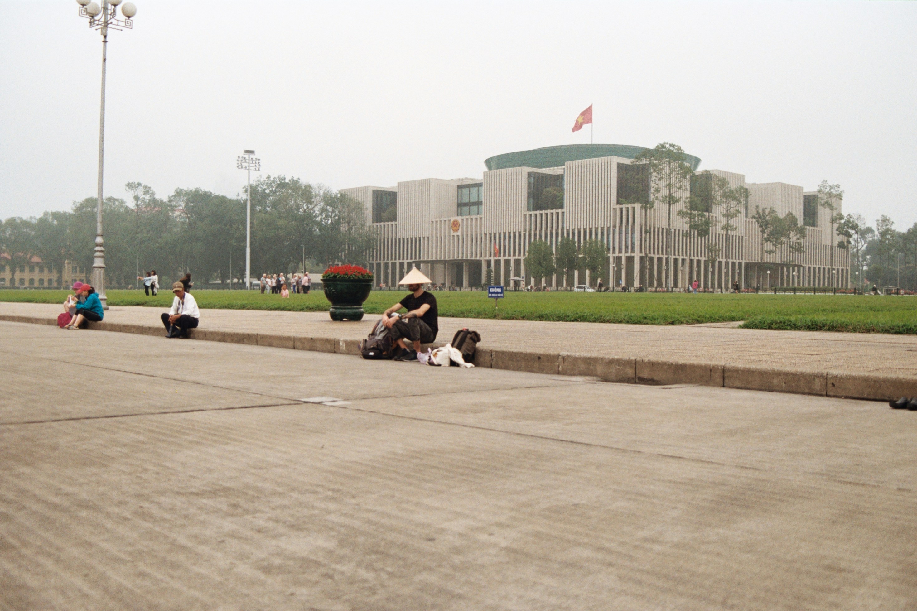 a group of people sitting on the side of a road