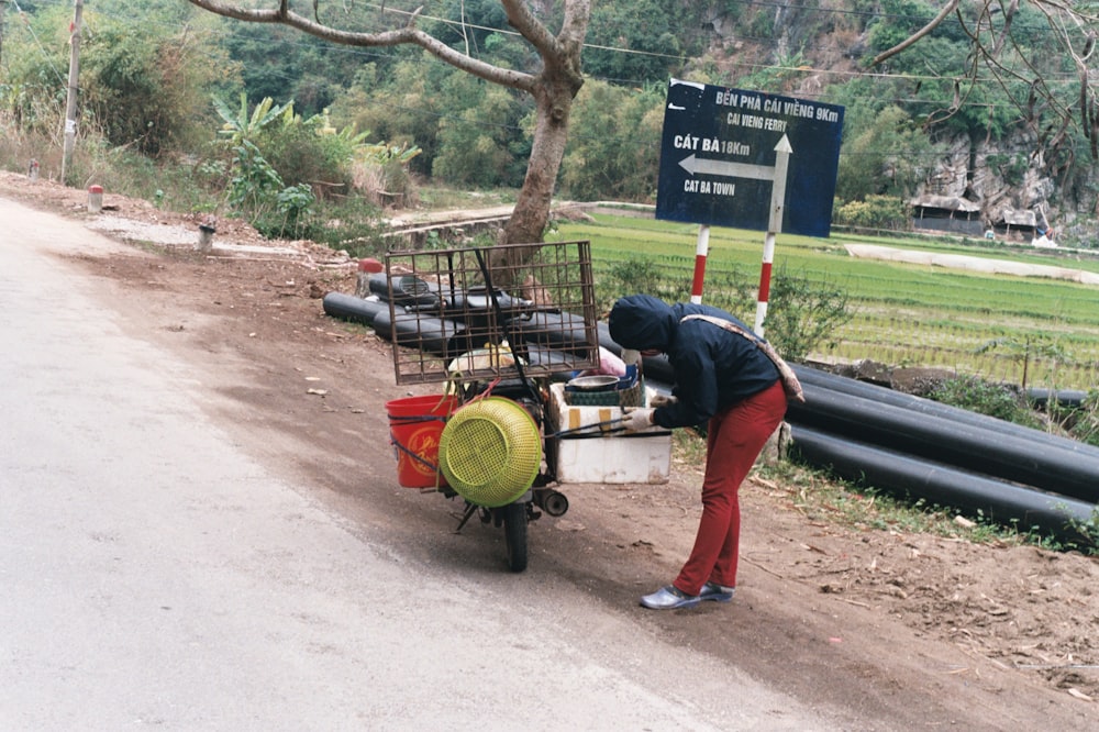 a person pushing a cart down a dirt road