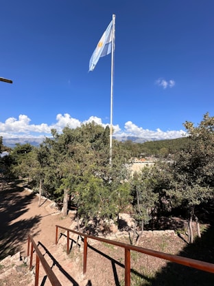 a flag flying in the wind on a sunny day