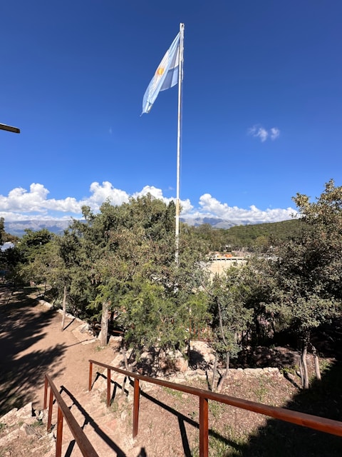a flag flying in the wind on a sunny day
