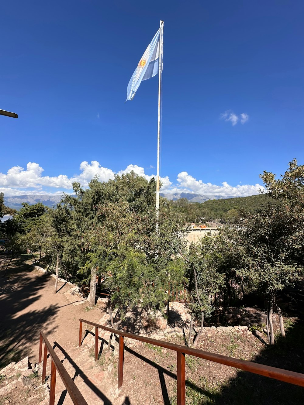 a flag flying in the wind on a sunny day