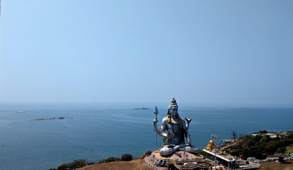 a statue of a person sitting on top of a hill