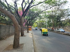 a yellow and green vehicle driving down a street