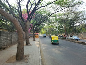 a yellow and green vehicle driving down a street