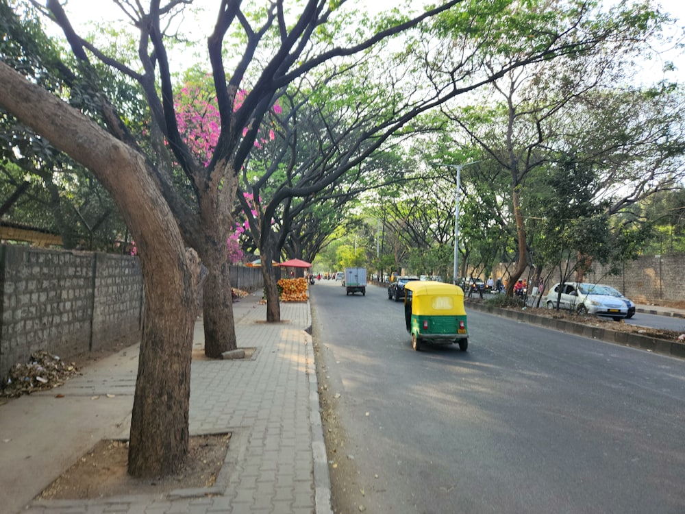 a yellow and green vehicle driving down a street