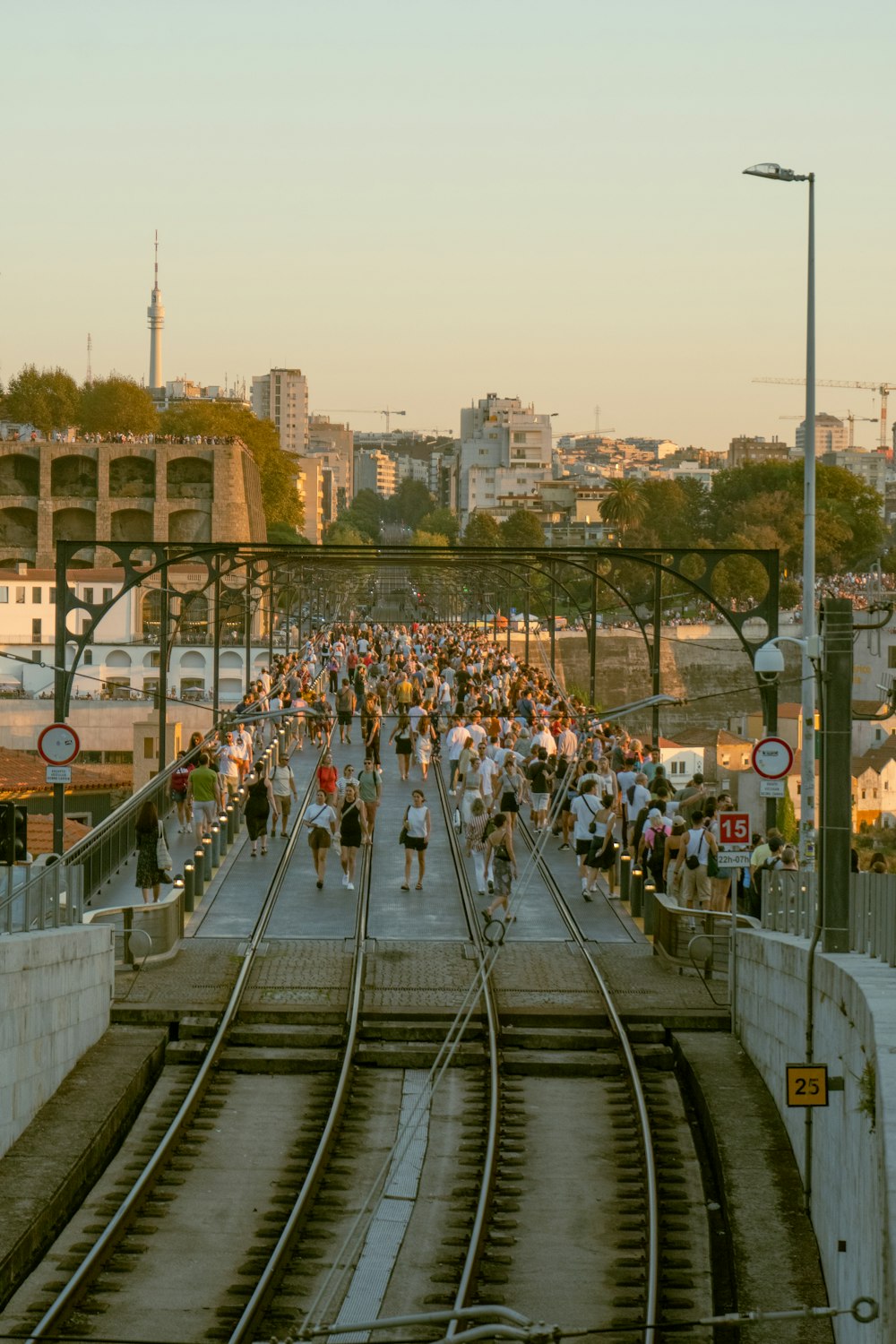 a large group of people running down a train track