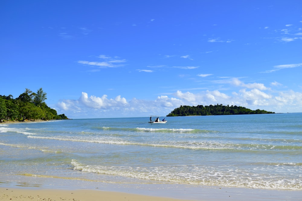 a boat is out on the water near a beach