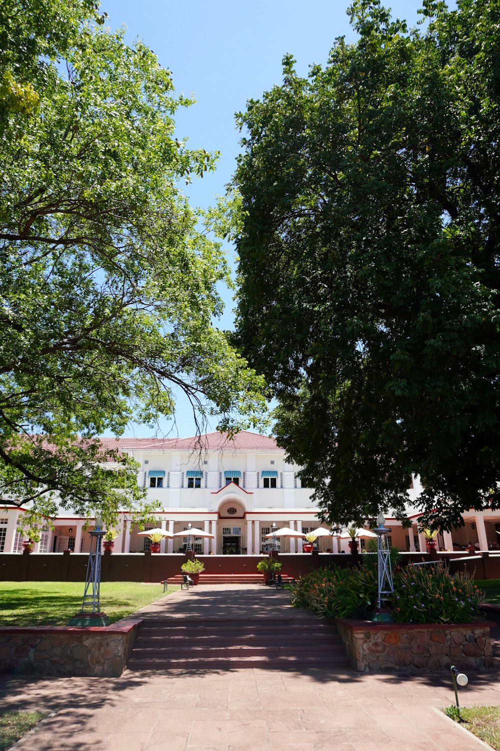 a large white building surrounded by trees on a sunny day