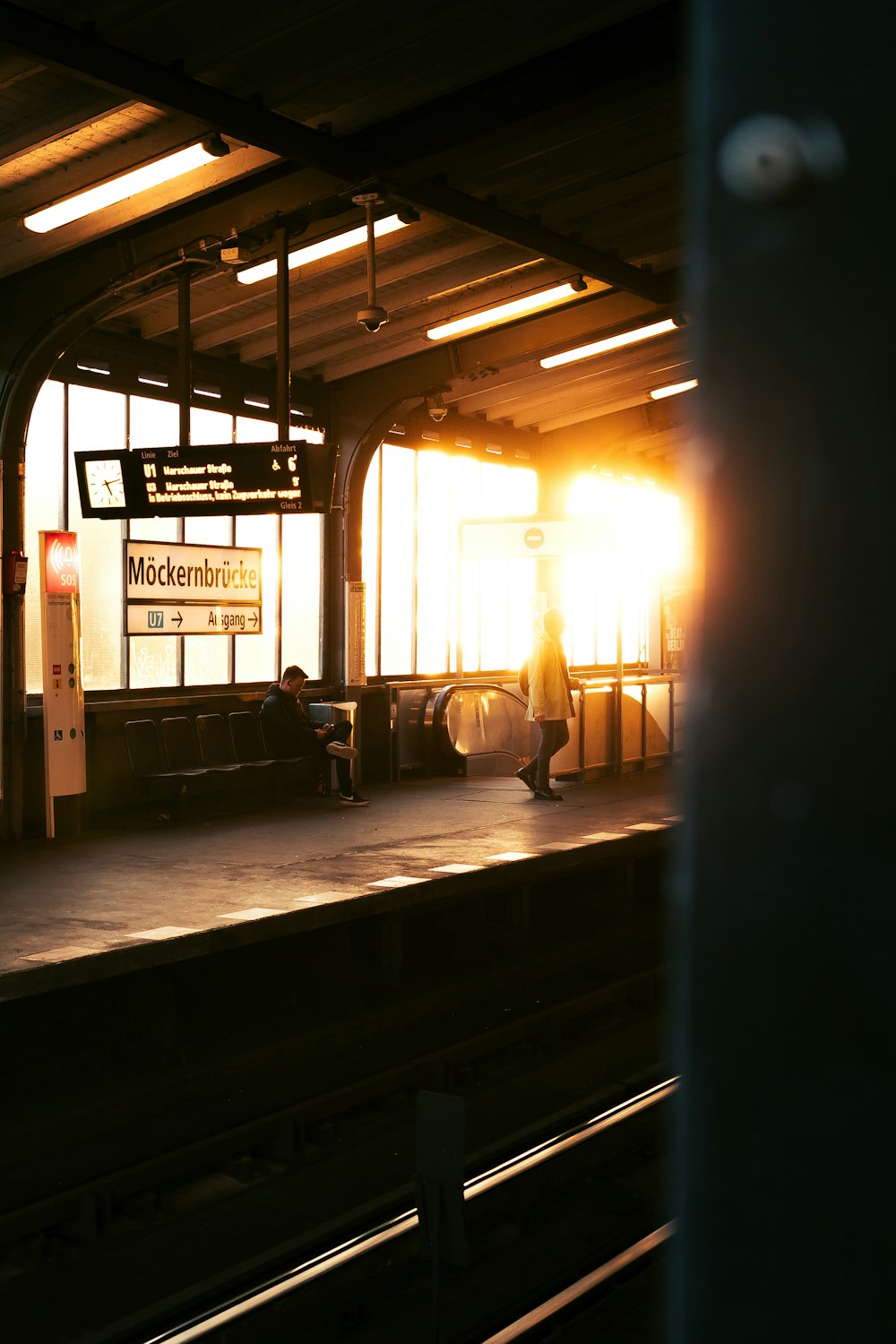 a person sitting on a bench at a train station