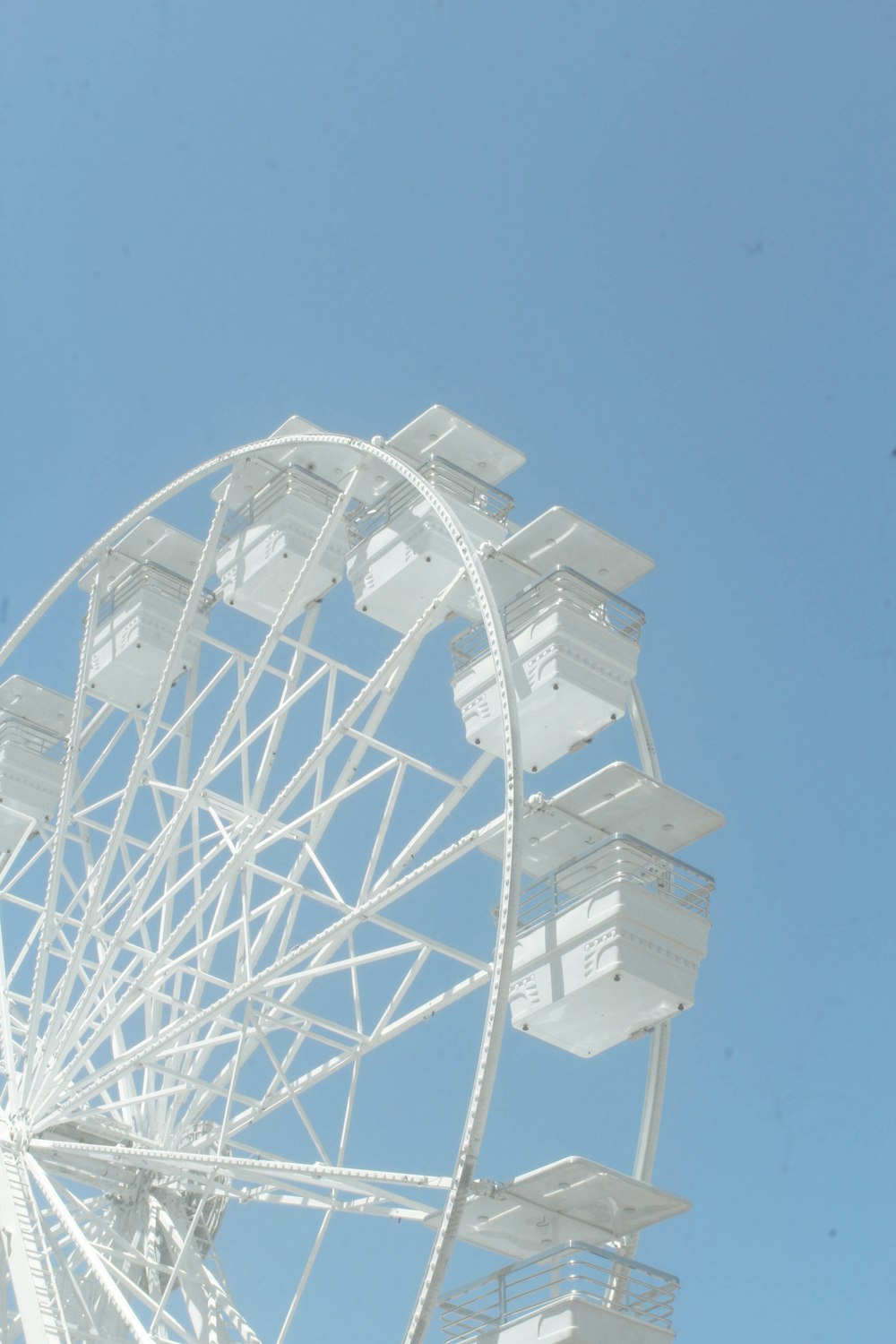 a white ferris wheel against a blue sky