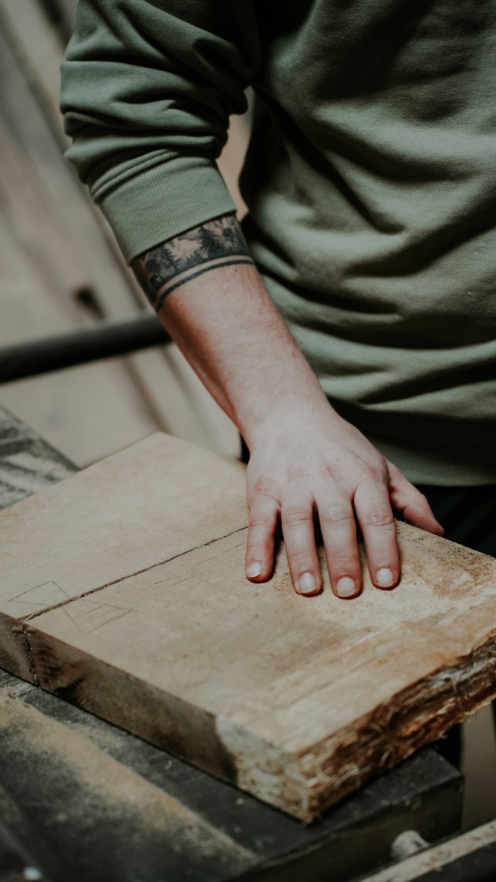 a person with their hand on a piece of wood
