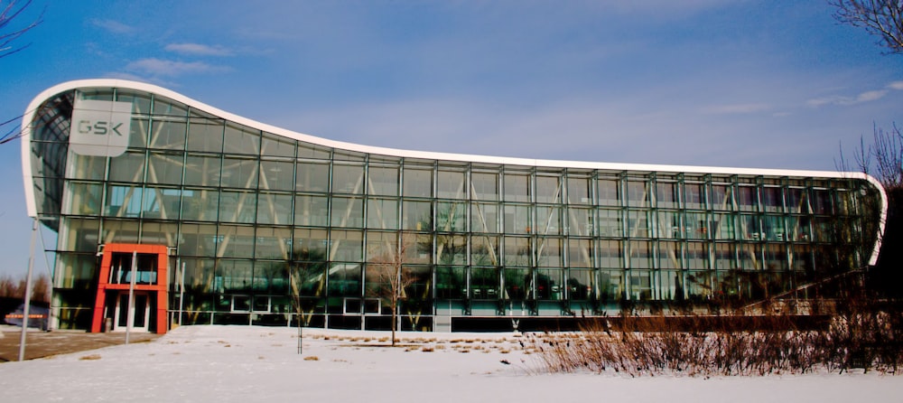 a large glass building with a red door in the snow