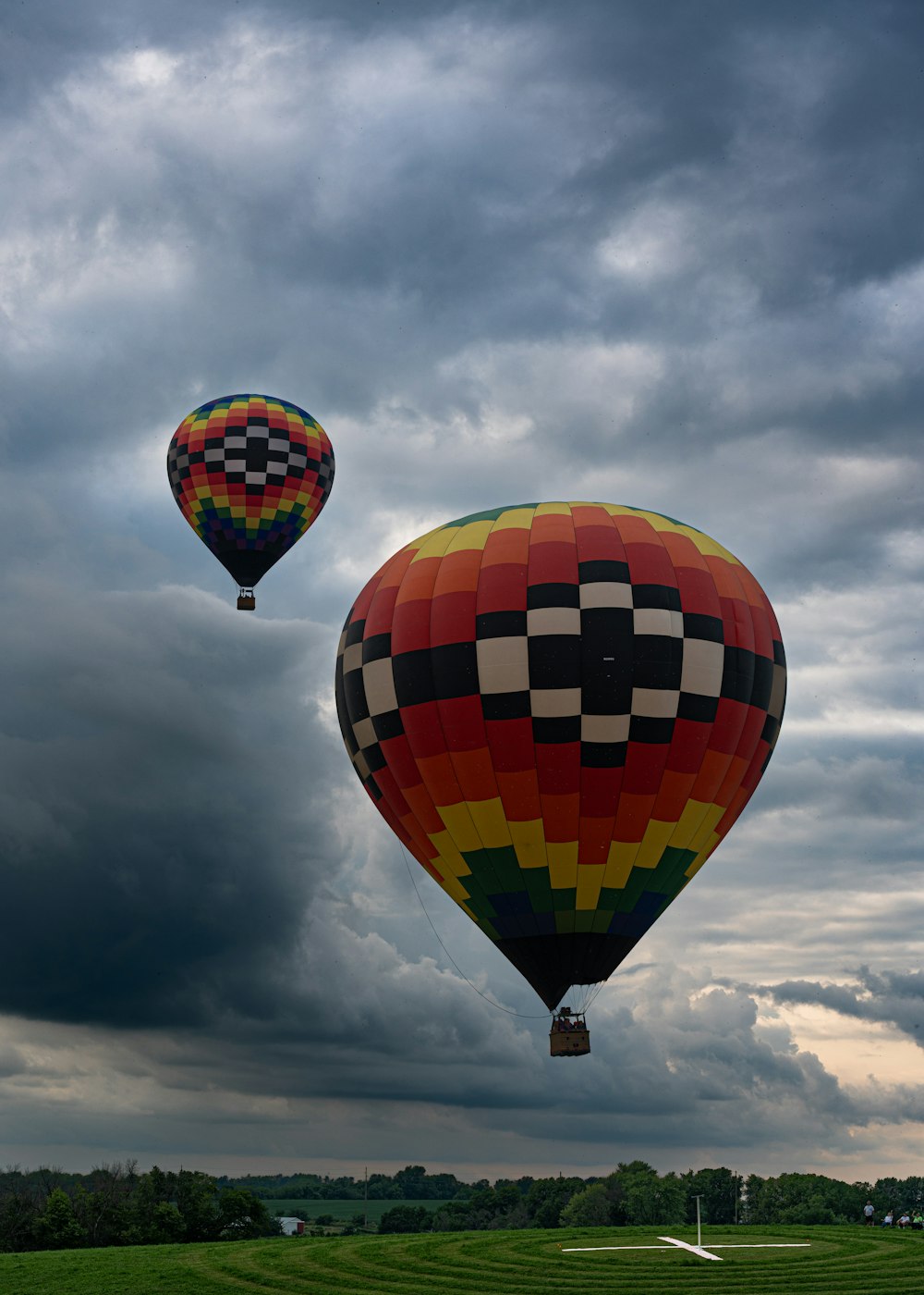 a couple of hot air balloons flying through a cloudy sky