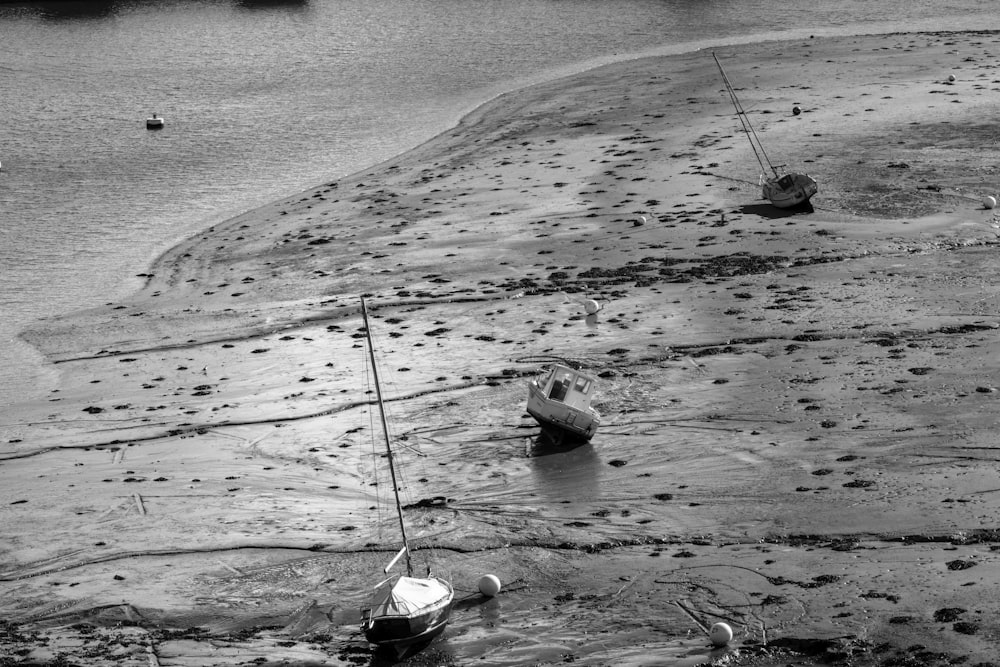 a couple of boats that are sitting in the sand