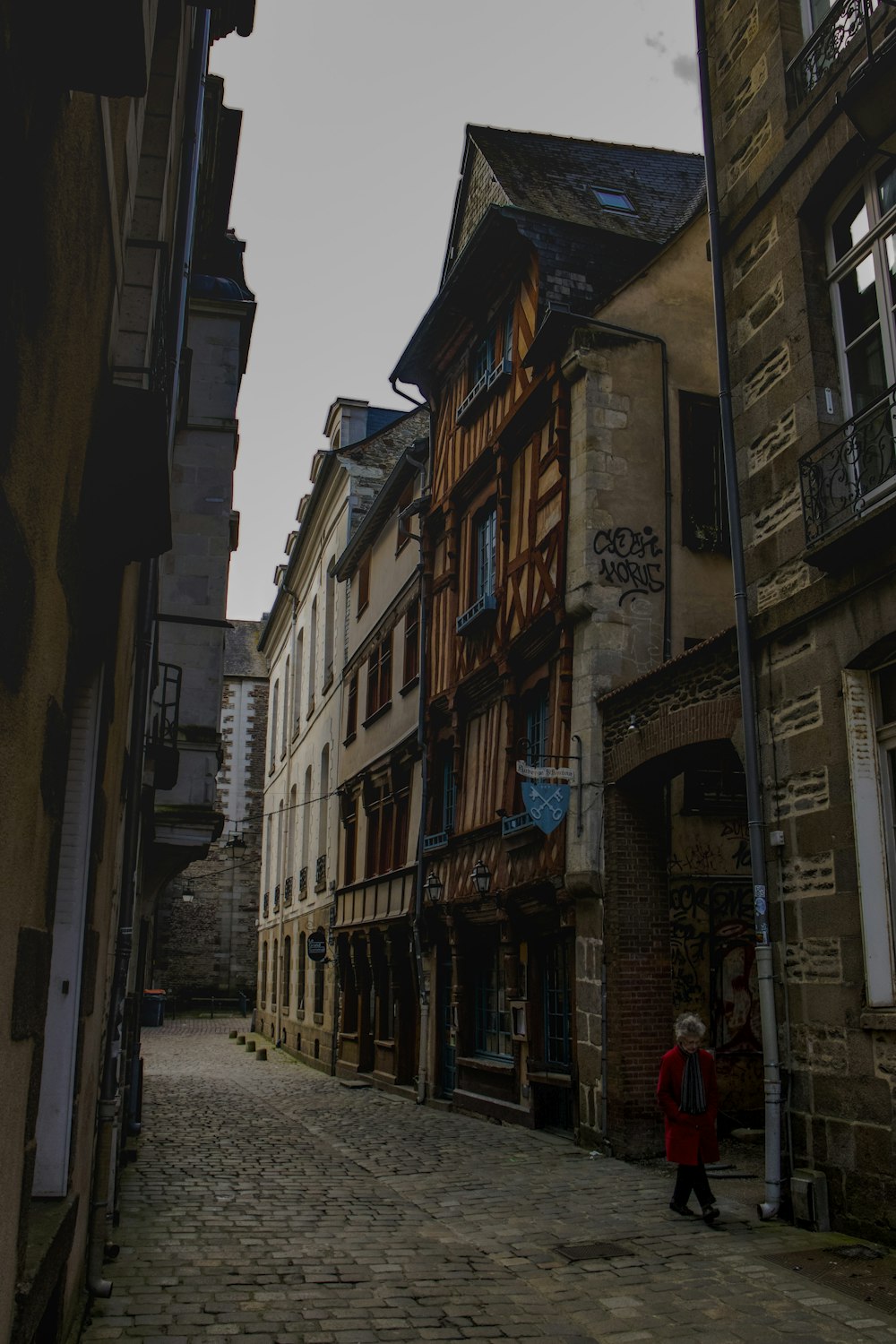 a person is walking down a cobblestone street