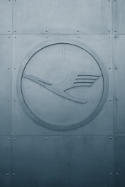 a circular metal sign on the side of a building