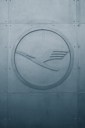 a circular metal sign on the side of a building