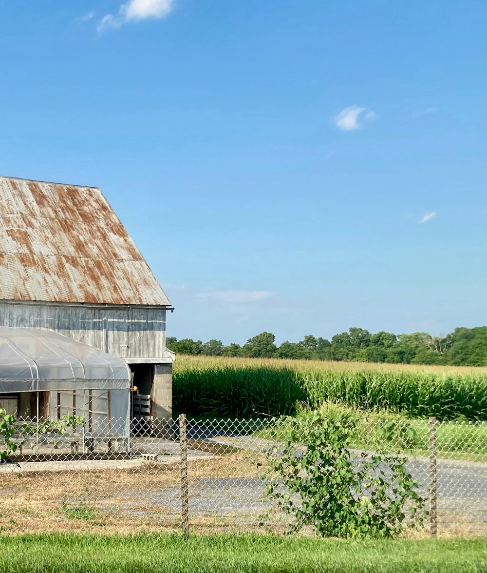 a barn in a field with a fence around it