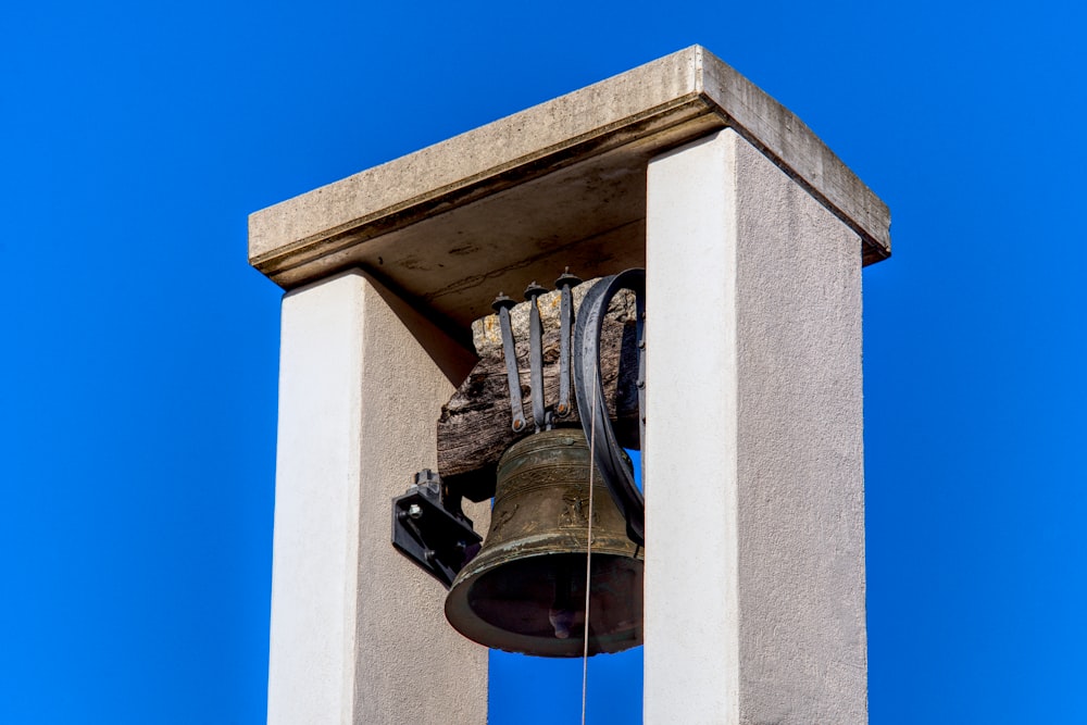 eine Glocke auf dem Dach eines Gebäudes mit blauem Himmel im Hintergrund