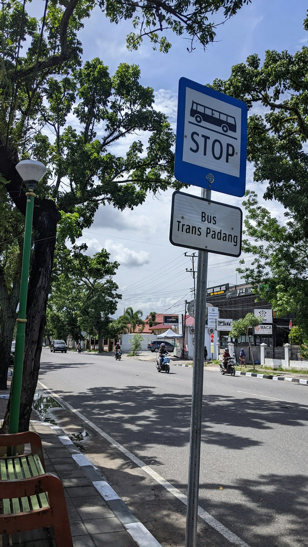 a bus stop sign sitting on the side of a road