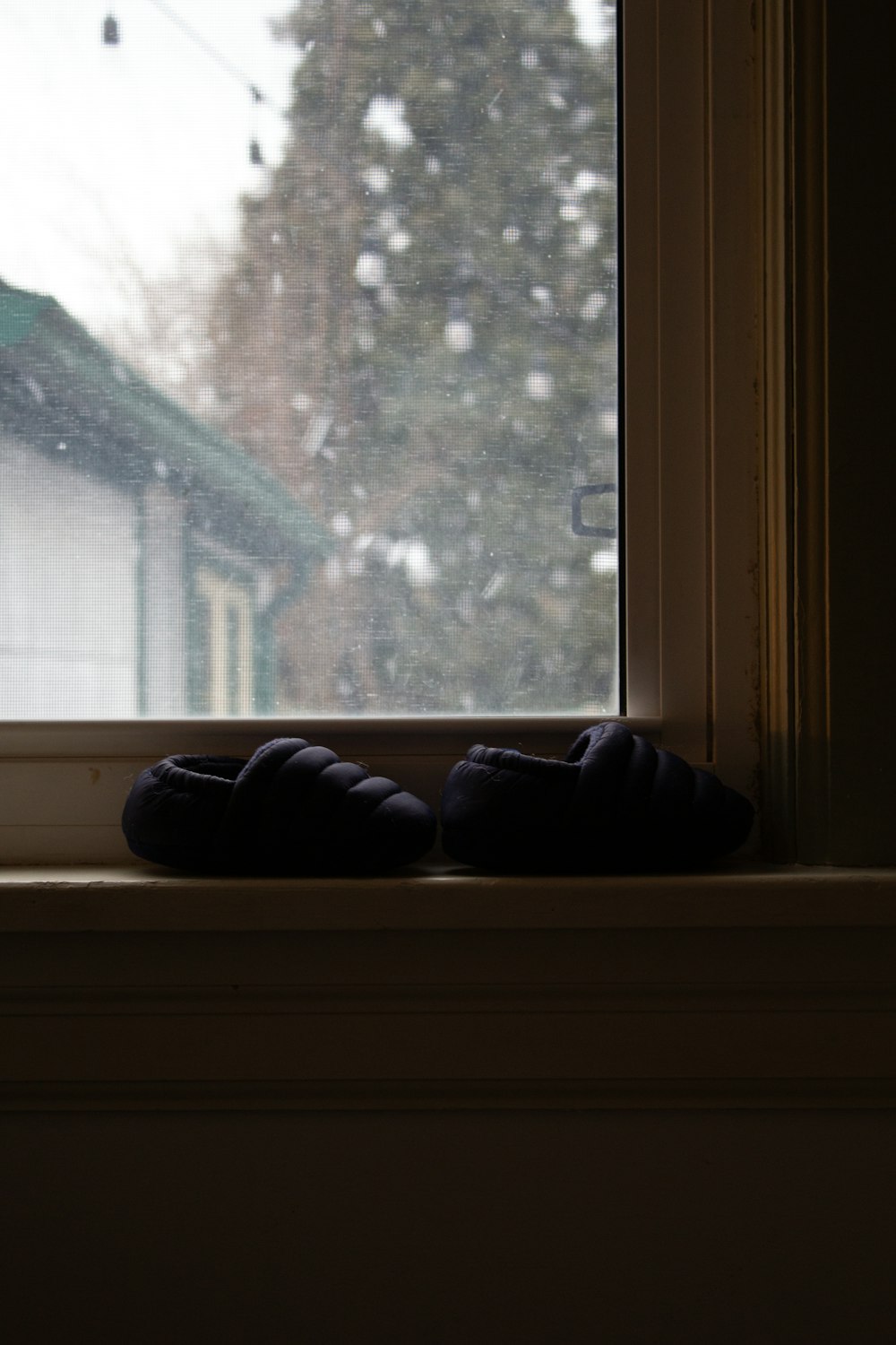 a pair of slippers sitting on a window sill