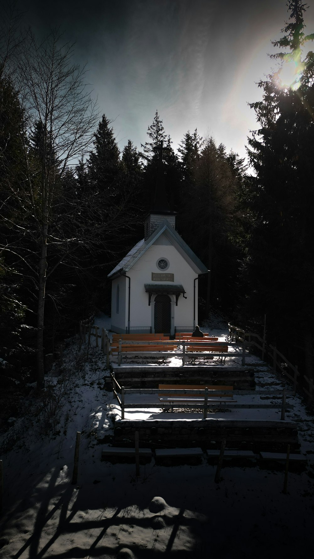 a small white church in the middle of a forest