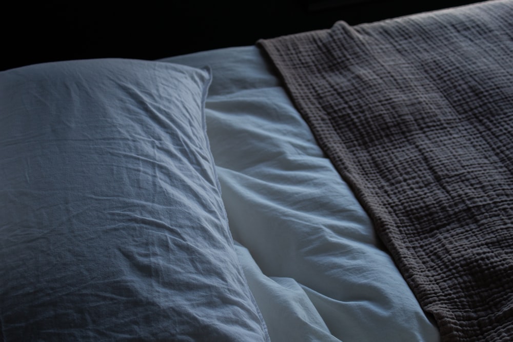 a close up of a bed with two pillows