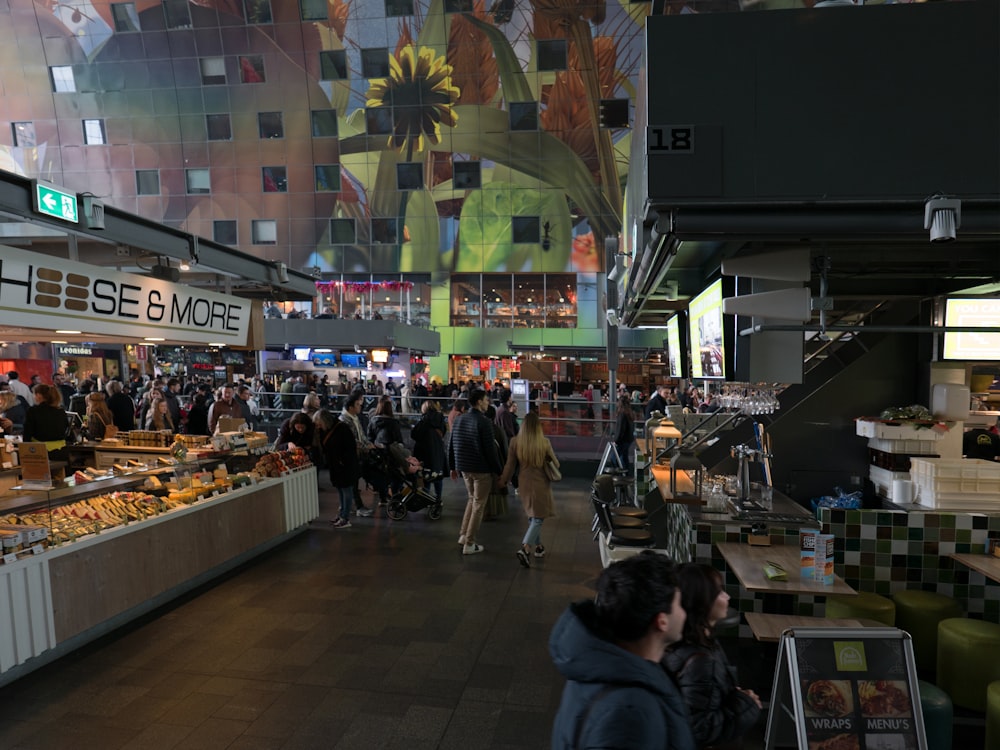 a large group of people walking around a market