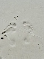two footprints in the sand of a beach