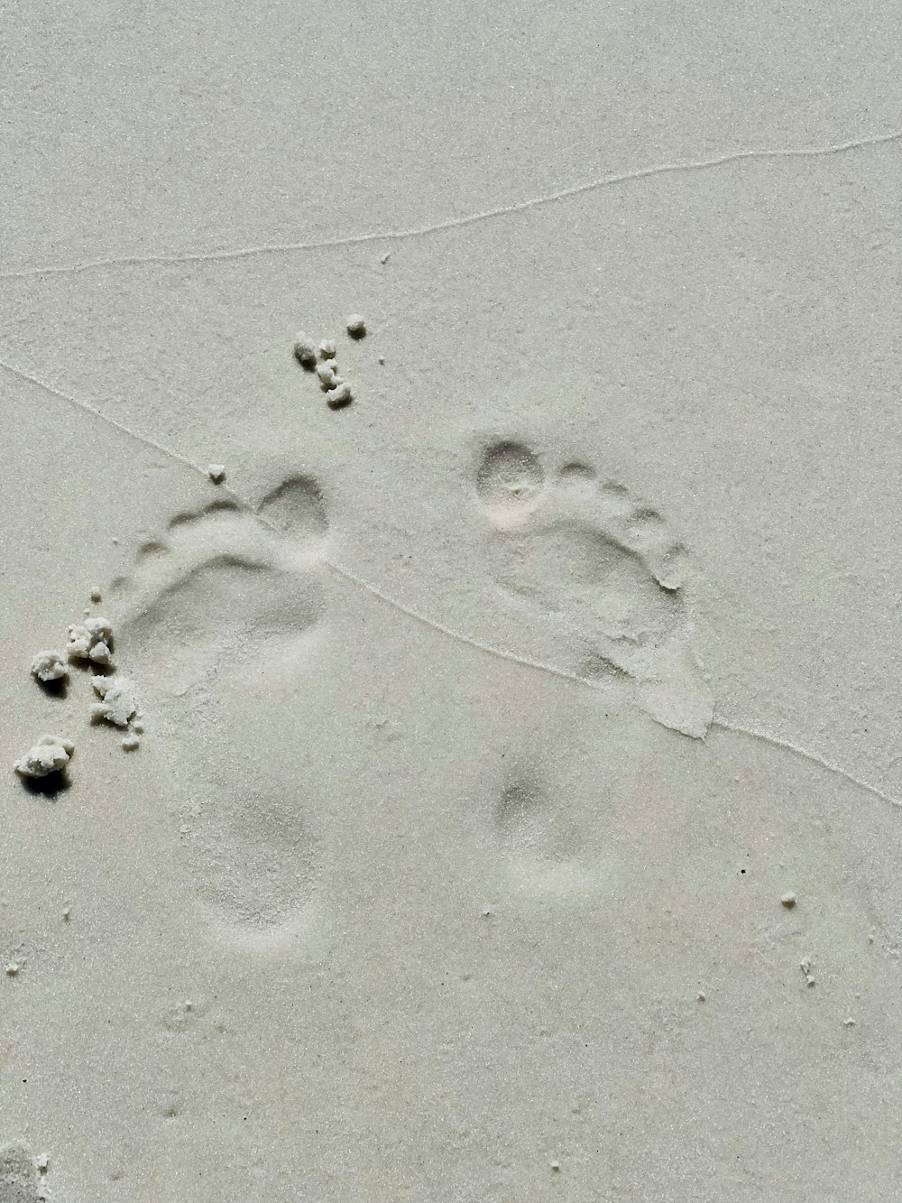 two footprints in the sand of a beach