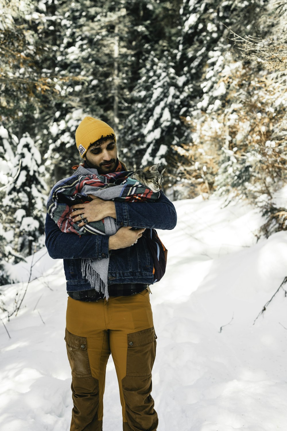 a man standing in the snow with his arms crossed