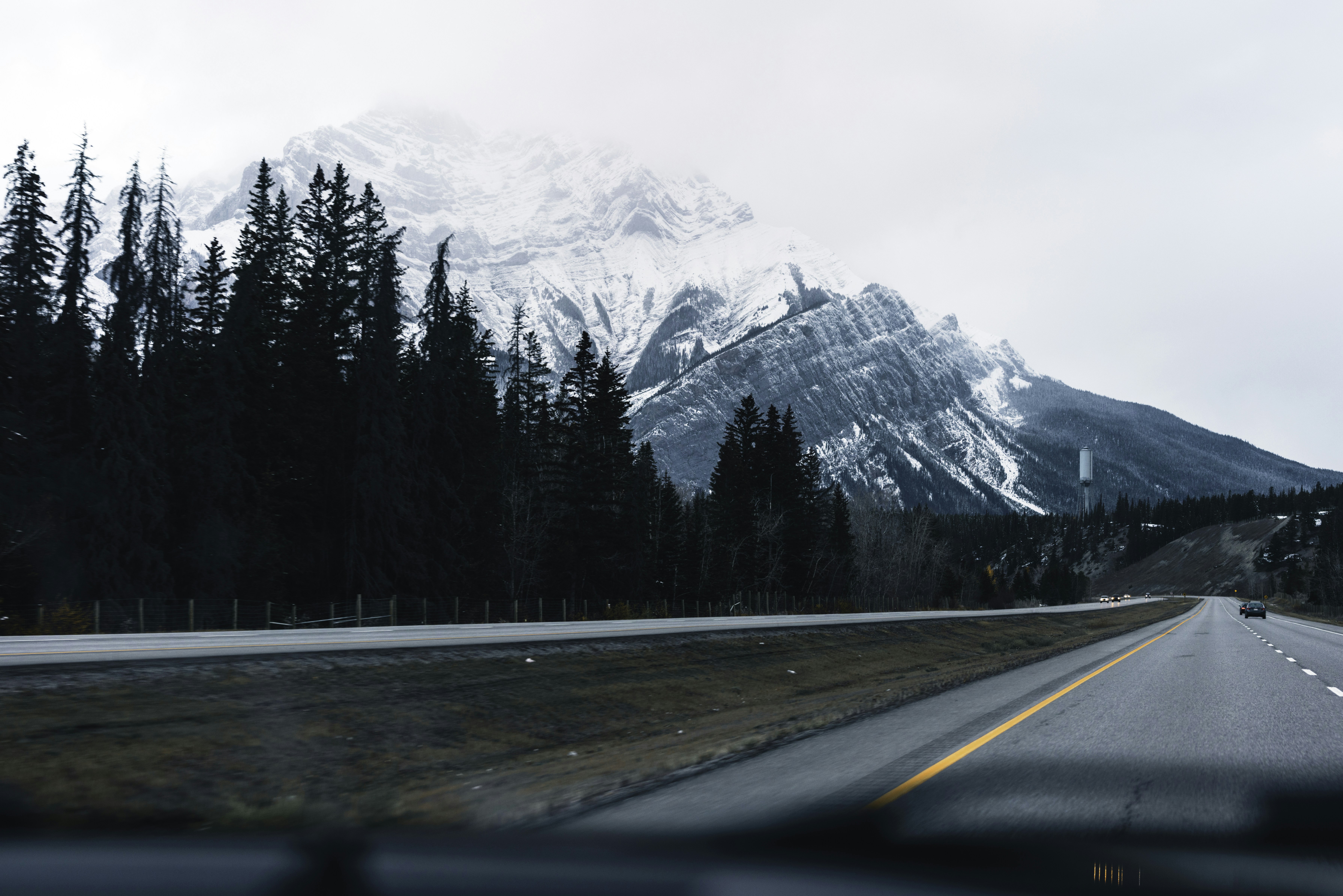 a car driving down a road with a mountain in the background