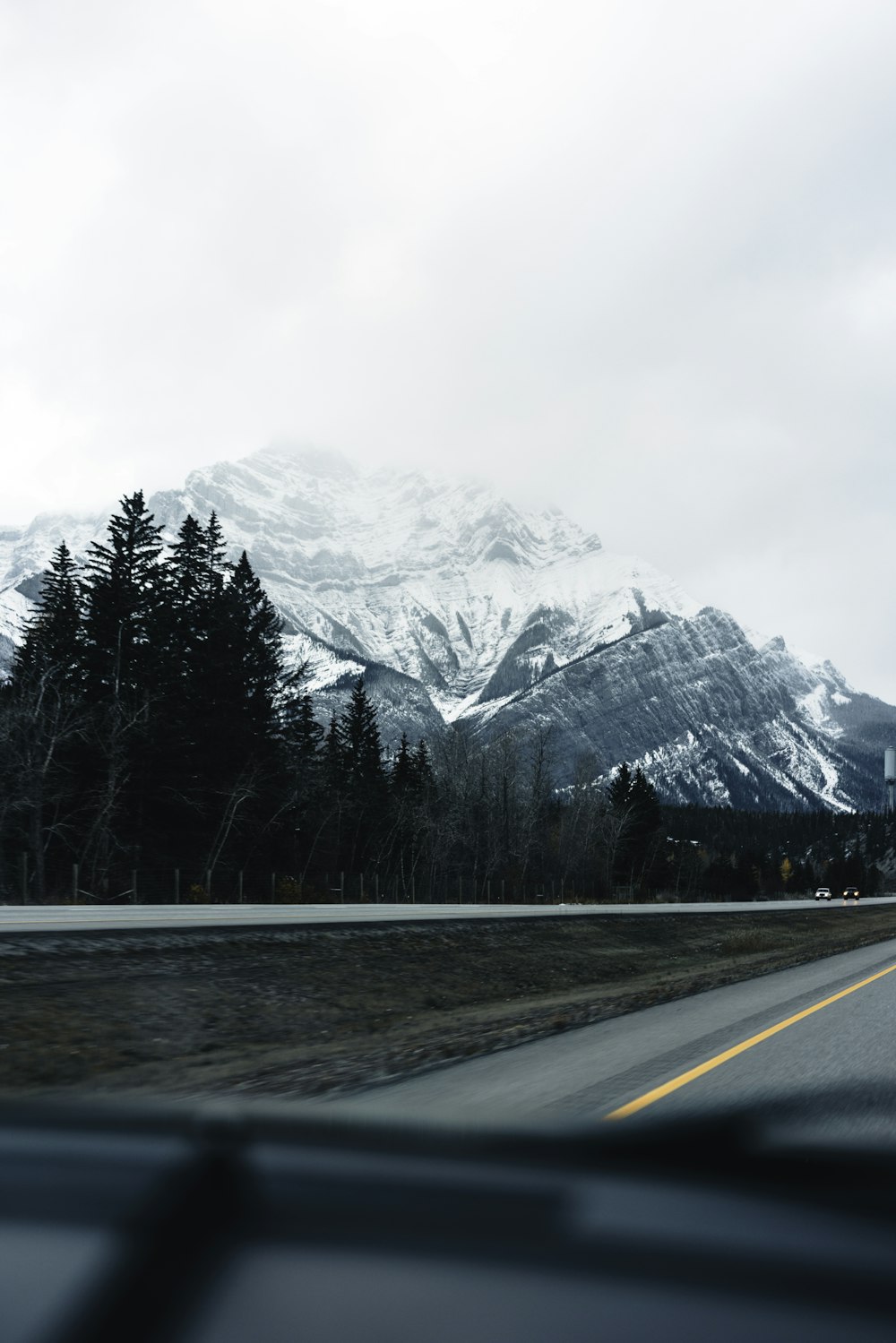 a view of a snow covered mountain from a car window