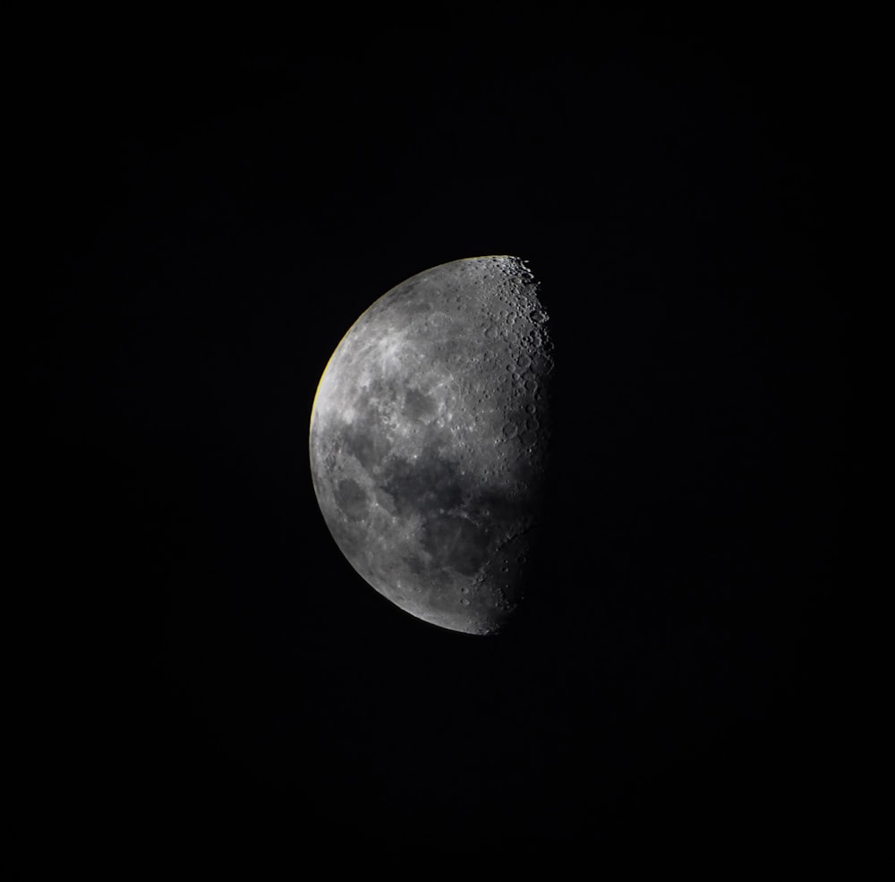 a half moon in the dark sky with a black background