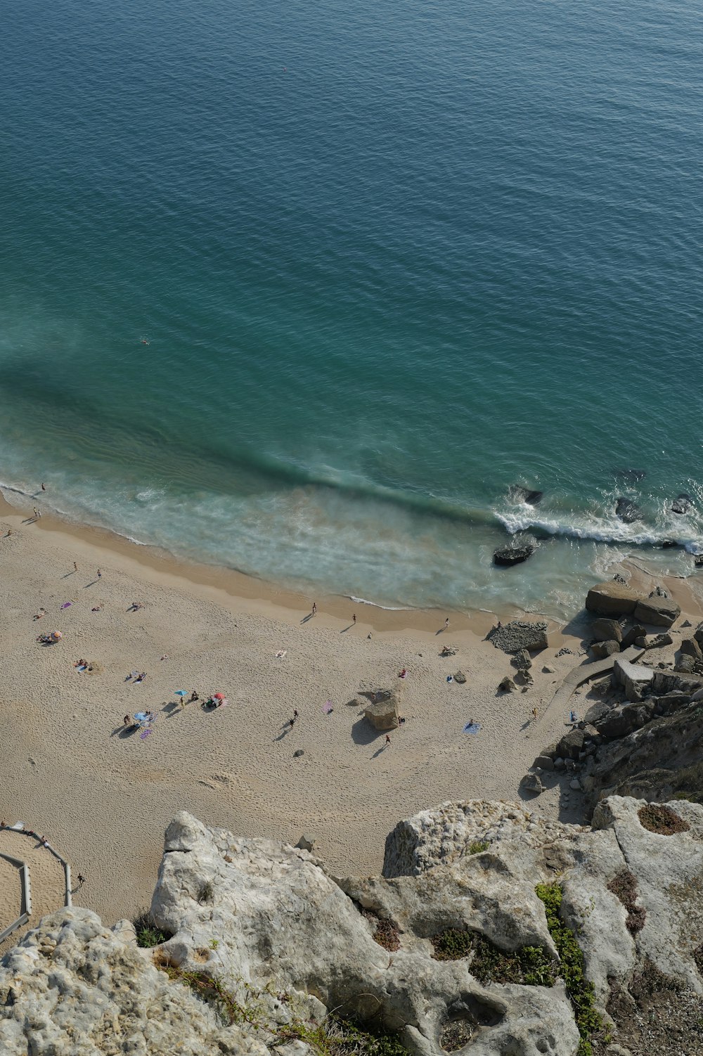 a beach with people on the sand and a body of water