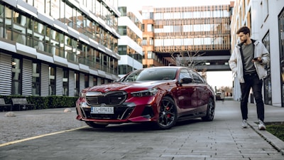 a man standing next to a red car