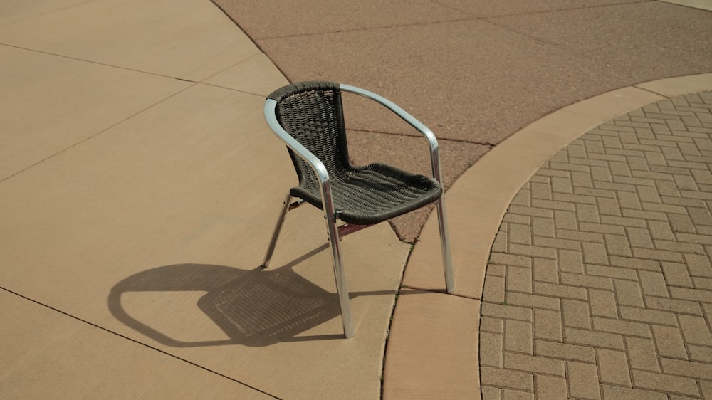 a chair sitting on a sidewalk next to a sidewalk