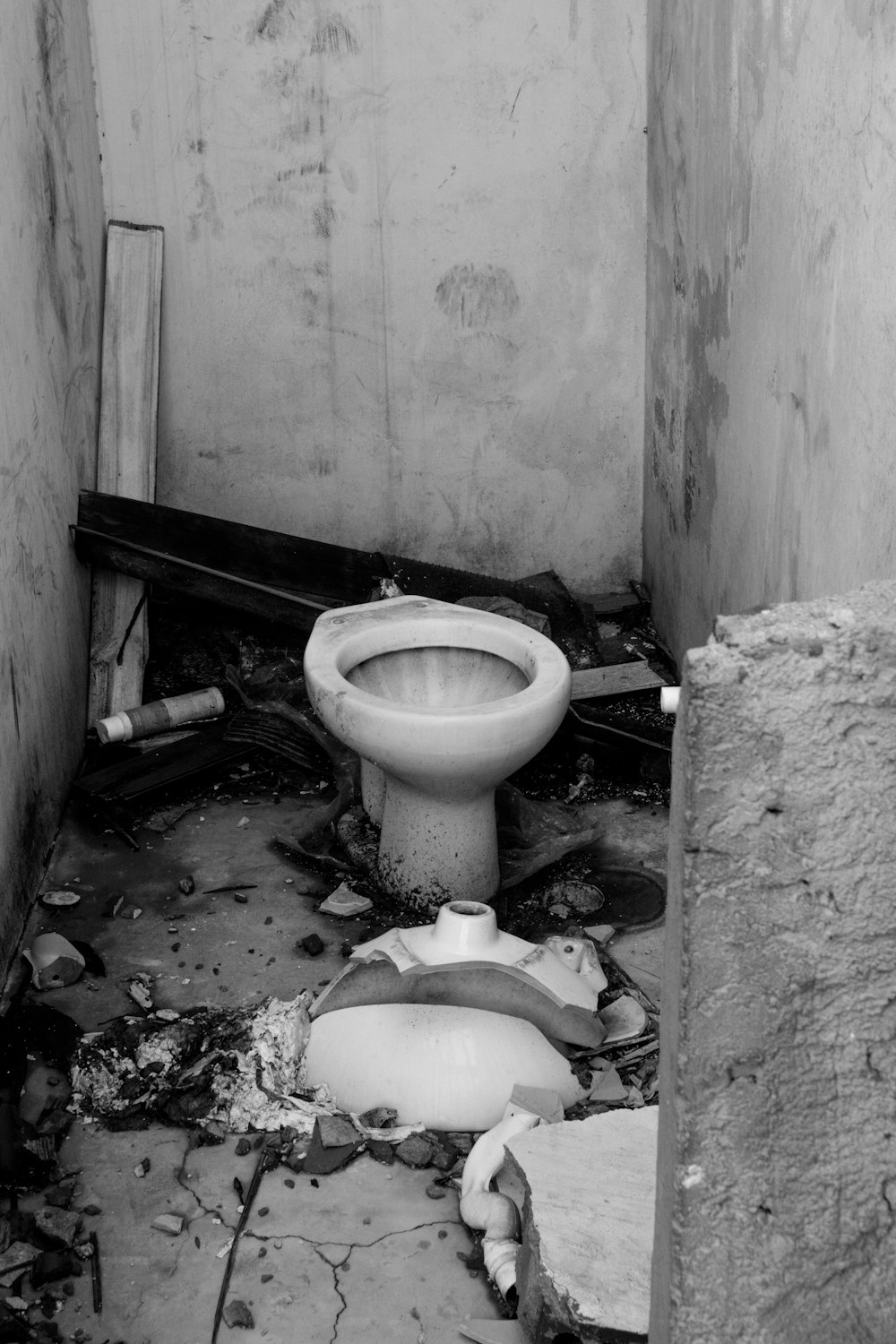 a dirty bathroom with a broken toilet in it