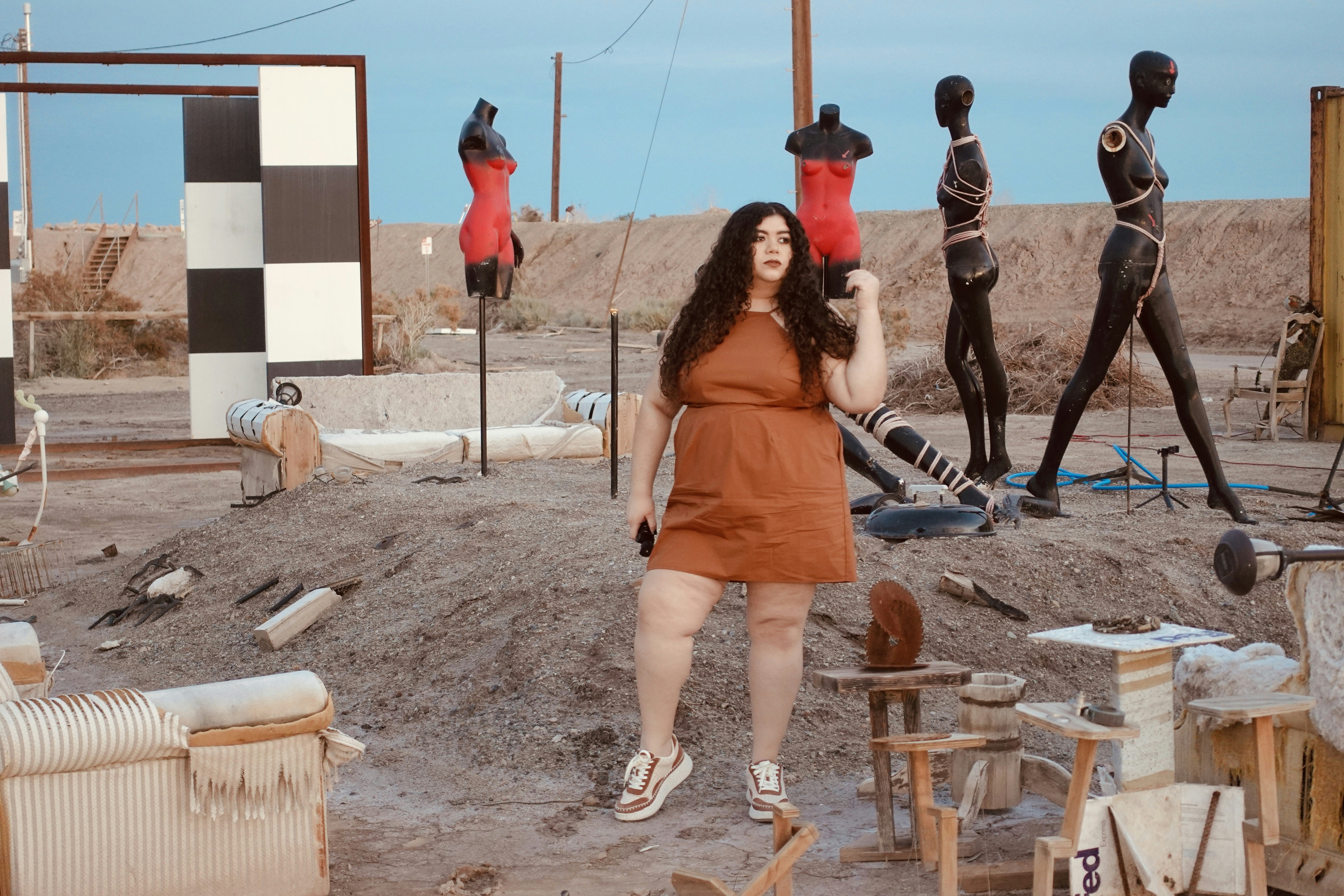 a woman standing in front of a group of mannequins