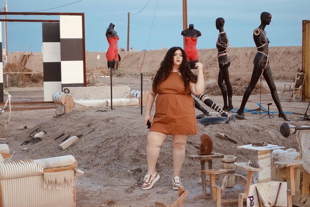 a woman standing in front of a group of mannequins