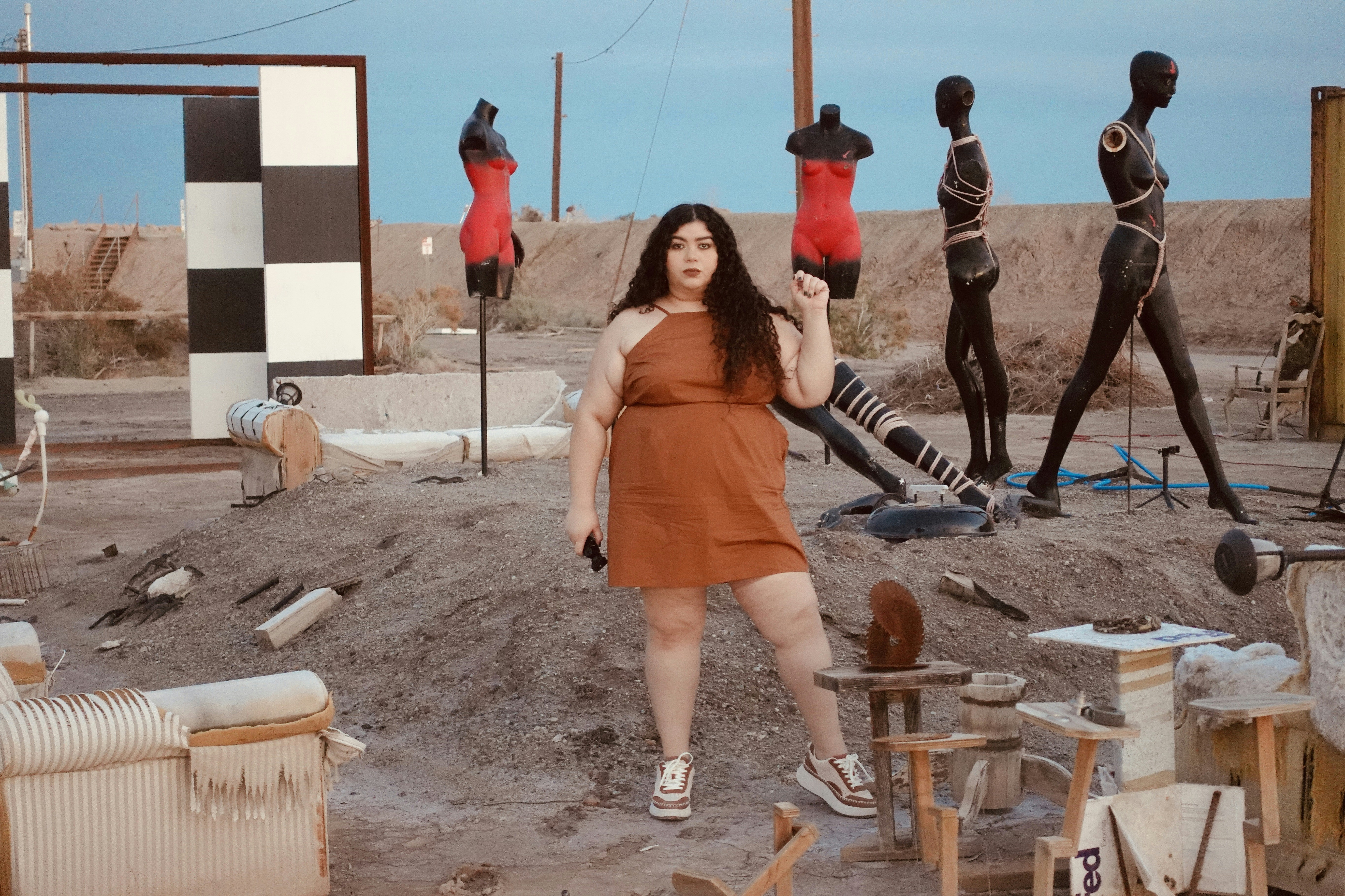 a woman standing in front of a group of mannequins