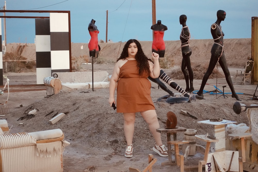 a woman standing in front of a group of mannequins