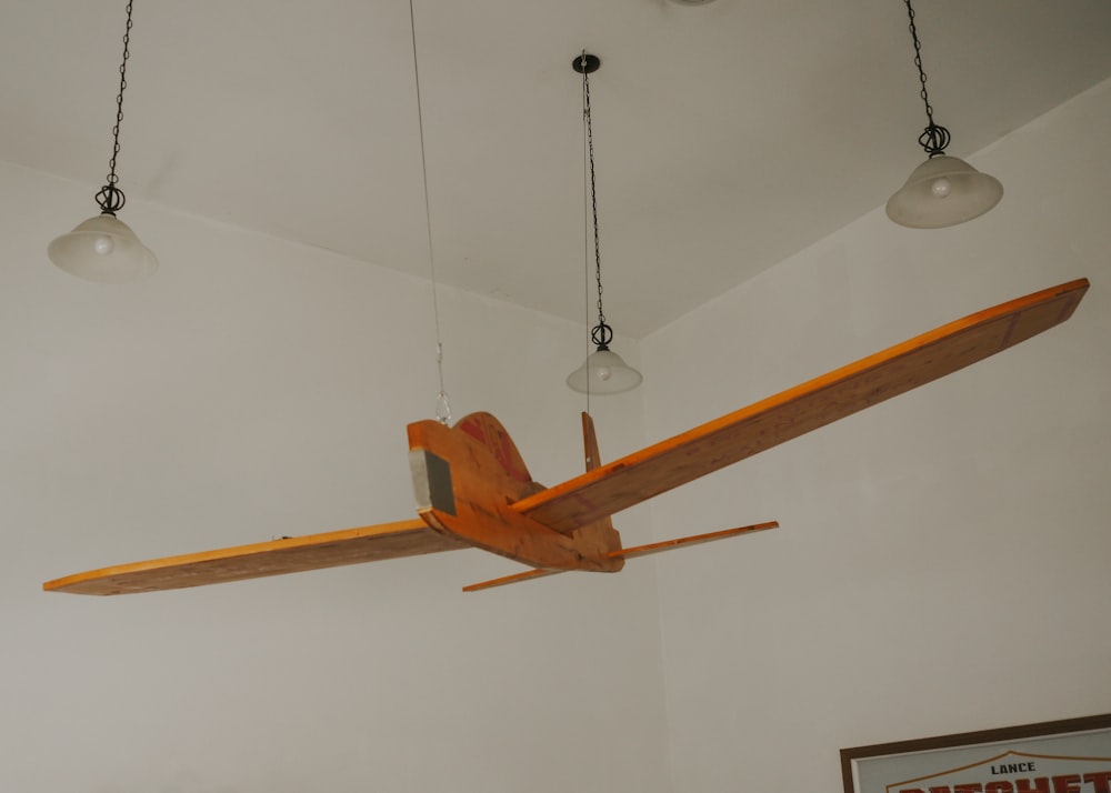 a wooden airplane hanging from a ceiling in a room